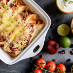 Traditional mexican enchiladas with chicken meat, spicy tomato sauce, corn, beans and cheese