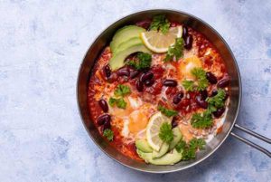 Eggs with Black Beans and Avocado in a pan