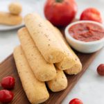 Garlic Butter Breadsticks with Pizza Sauce and tomatoes in the background