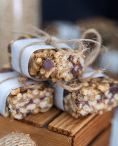 Chocolate Cherry Crispy Rice Treats wrapped in parchment paper on a wooden block