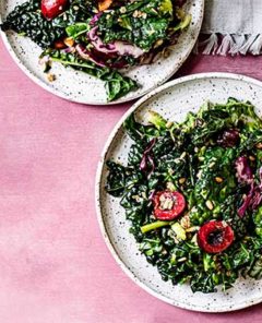 Bourbon Cherry Kale Salad on a white plate on a pink background