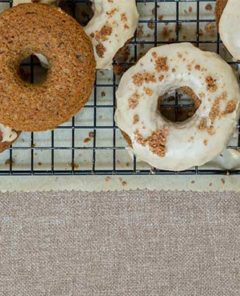 Applesauce Doughnuts on a wire cooling rack set over parchment paper on a burlap background