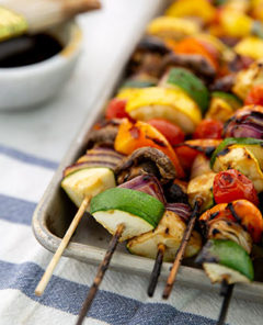 Closeup of Grilled Veggie Skewers with dipping sauce in the background