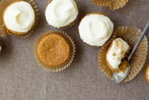 Sweet Potato Cupcakes with white creamy frosting on a burlap background