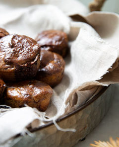 Chocolate Flourless Muffins in a silver pan with beige rustic napkin inside the pan