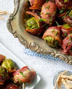 Overhead view of Maple Dijon Glazed Bacon-Wrapped Brussels Sprouts on a vintage platter on a lace tablecloth