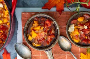 Sweet Potato & Leftover Turkey Soup in gray bowls with fall leaves in the background on an orange placemat