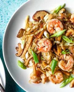 Shrimp Stir-Fry on a white plate on a teal colored background